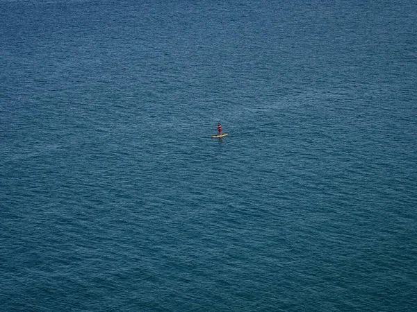Aerial view of one single young man on a stand up paddle sports activity in Abel Tasman National Park South Island New Zealand