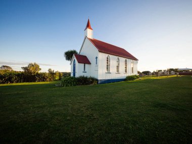Old historic 19th century white presbyterian Awhitu Central Church with green grass during sunset on Manukau Heads Peninsula Auckland North Island New Zealand