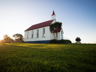 Old historic 19th century white presbyterian Awhitu Central Church with green grass during sunset on Manukau Heads Peninsula Auckland North Island New Zealand