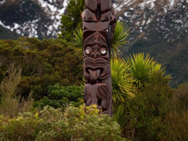 Dawson Falls Taranaki Kuzey Adası Yeni Zelanda 'sında bitki geçmişi olan Maori kültüründen tipik Pou Whenua ahşap direği Whakairo oymalarının ayrıntılı görüntüsü