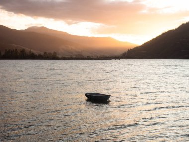 Grove Arm Jetty, Okiwa Körfezi, Kraliçe Charlotte Sound, Picton, Marlborough, Güney Adası, Yeni Zelanda 'da demirlemiş küçük bir teknenin gün batımı manzarası