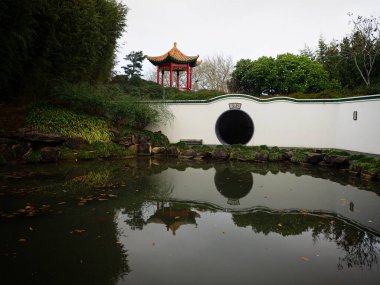 Hamilton Gardens Waikato Kuzey Adası Yeni Zelanda 'daki Çin âlimleri bahçesinde geleneksel Çin mimarisinin ayna gölü yansıması.