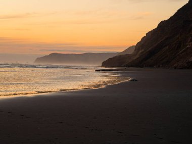 Rahatlatıcı turuncu pastel gökyüzü altın saat batımı doğa sahnesi Hamiltons Gap Awhitu Yarımadası Auckland Bölgesi Kuzey Adası Yeni Zelanda 'nın batı kıyısı