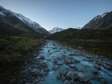 Alp doğası manzarası Hooker Vadisi 'nin kar manzarası dağları, yeşil vadi ve Aoraki Dağları' ndaki Turkuaz Buzul nehri Güney Alpleri Canterbury Güney Adası Yeni Zelanda