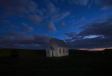 Auckland Kuzey Adası Yeni Zelanda yakınlarındaki Awhitu Yarımadası 'ndaki yeşil çayır otlağının üzerindeki Kohekohe Kilisesi' ndeki İdealist uzak beyaz presbiteryen kilisesi.