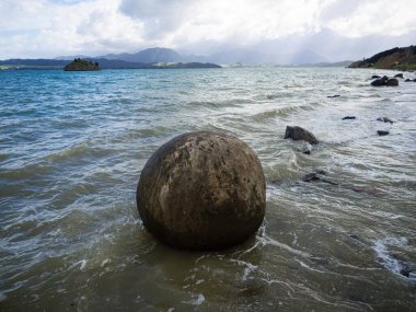Koutu Boulders küresel yuvarlak şekilli kaya oluşumları Hokianga Limanı sahil kıyısı Opononi Northland Kuzey Yeni Zelanda 'daki beton jeolojik fenomen.