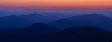 Carpathian dağlarının doğal mavi-kırmızı eğimli Panorama siluetleri. Alacakaranlıkta, tepeler ve tepeler siluetleriyle Karpat Dağları 'nın panoraması. Gorgany, Karpatlar, Ukrayna.