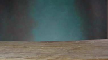 Beyaz bir adamın elleri ahşap bir masaya iştah açıcı bir burger koydu. Man Cheeseburger 'i yeşil arka plandaki masaya koyar. Kapat.