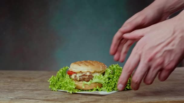 Zbliżenie Rąk Białego Mężczyzny Weź Soczystego Burgera Drewnianego Stołu Mężczyzna — Wideo stockowe