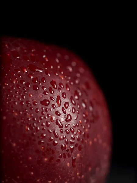 黒の背景に水滴が付いている赤いジューシーなアップルのマクロショット 孤立してる コピースペース 閉じろ — ストック写真