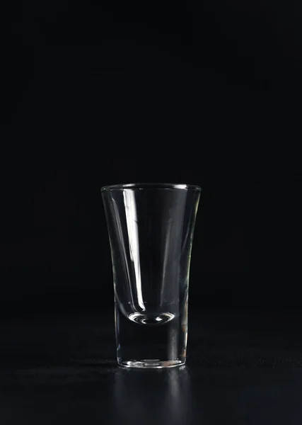 在黑色背景上垂直拍摄的空伏特加 一个黑色背景的空杯子 复制空间 — 图库照片