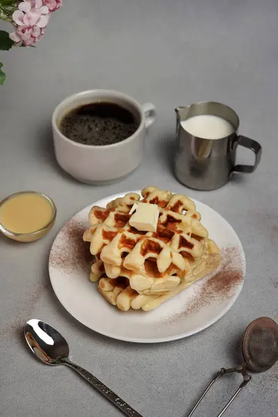 stock image Homemade of tasty Waffles Plate, Caramel Sauce, Coffee Cup, Milk on a Grey Background