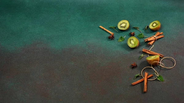 Snijdt Verse Sappige Kiwi Een Groene Achtergrond Versierd Met Kaneelstokjes — Stockfoto