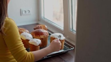 Kafkas Kız Eli yeni pişmiş Paskalya Pastalarına beyaz jöle sürüyor. Ev yapımı geleneksel Paskalya Pastaları