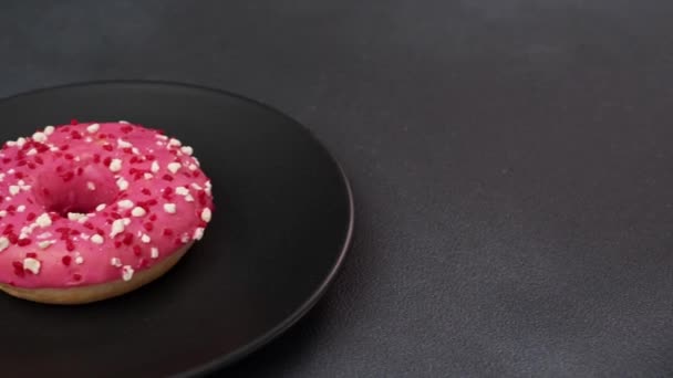 Крупный План Розового Глазированного Пончика Красочными Брызгами Черной Тарелке Розовый — стоковое видео