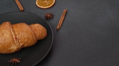 Lezzetli, yeni pişmiş kruvasanın kapağı siyah bir tabakta uzanır.