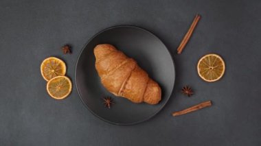 Lezzetli, yeni pişmiş kruvasan 'ın siyah bir arka planda, siyah bir tabakta yatışı.