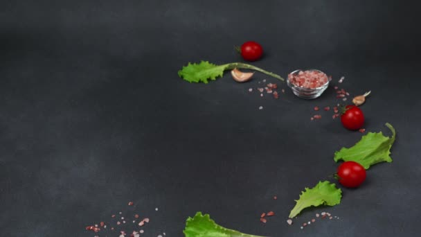 一个高加索人的手的特写把一盘凯撒沙拉放在桌上 凯撒沙拉 生菜叶 樱桃西红柿 烤意大利面在一个黑色盘子里 — 图库视频影像
