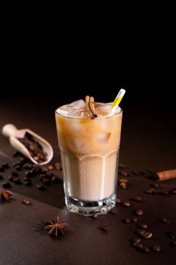 Buzlu kapuçino, uzun bir bardakta siyah arka planda. Sütlü buzlu kahve.