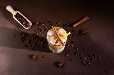 Kapuçino 'nun en üst görüntüsü. Buz küpleri, uzun bir bardakta, siyah arka planda. Sütlü buzlu kahve.