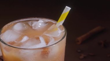 Kapuçinonun kapuçinosu, uzun bir bardakta buzla kaplanmış, siyah bir arka planda. Sütlü buzlu kahve.