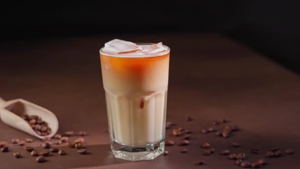 Cappuccino Kostkami Lodu Wysokiej Szklance Czarnym Tle Mrożona Kawa Mlekiem — Wideo stockowe