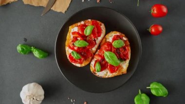 Ricotto peyniri ve vişneli domates fesleğen, siyah arka planda sarımsak. Yiyecekler. Yemek arkaplanı. Üst görünüm