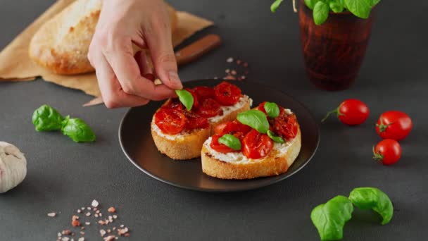 意大利面 意大利乳酪和樱桃番茄 大蒜在黑色背景 男人的手用罗勒装饰着番茄酱和番茄酱 — 图库视频影像