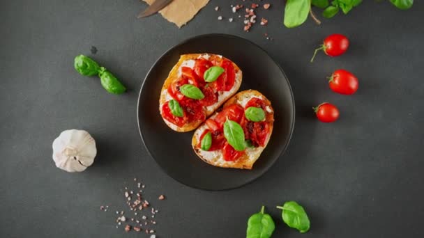 Bruschetta Serem Ricotto Pomidorami Wiśniowymi Bazylią Czosnkiem Czarnym Tle Jedzenie — Wideo stockowe