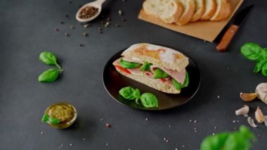 Jambonlu Ciabatta Sandviçi, Pesto sosu, Domates, siyah arka planda Basil. Yiyecekler. Gıda arkaplanı