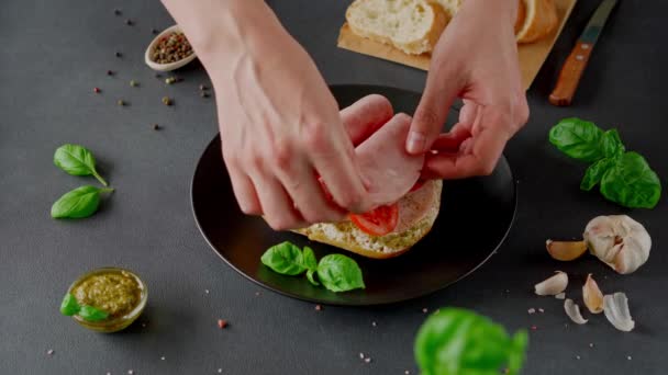 Mannen Handen Bereiden Chiabatta Sandwich Met Ham Basilicum Pesto Saus — Stockvideo