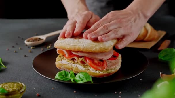 Męskie Ręce Przygotować Chiabatta Kanapka Szynką Bazylia Sos Pesto Pomidory — Wideo stockowe
