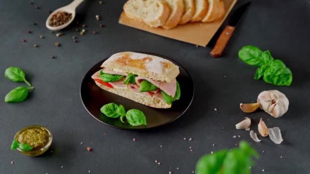 Ciabatta Sandwich Ham Pesto Sauce Tomatoes Basil Black Background Food — Stock Video