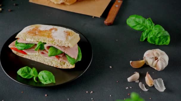 Sandwich Ciabatta Com Presunto Molho Pesto Tomates Manjericão Sobre Fundo — Vídeo de Stock
