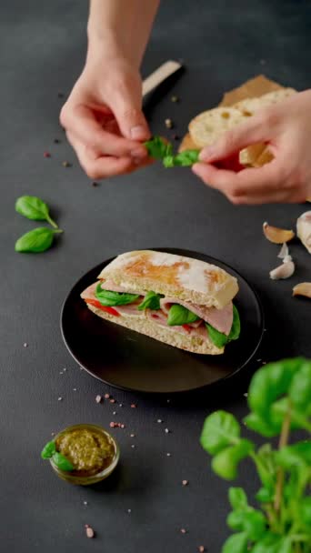 Man Hands Decorates Chiabatta Sandwich Ham Basil Pesto Sauce Tomatoes — Stock Video