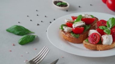Domatesli, mozzarellalı ve açık arkaplanlı fesleğenli Crostino Caprese