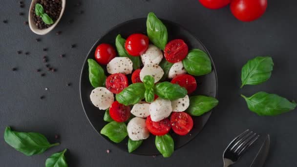토마토와 모차렐라 치즈가 카프리스 샐러드의 과검은 배경에 모차렐라 이탈리아 — 비디오