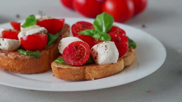 Zbliżenie Caprese Bruschetta Świeżymi Pomidorami Mozzarellą Liśćmi Bazylii Jasnym Tle — Wideo stockowe