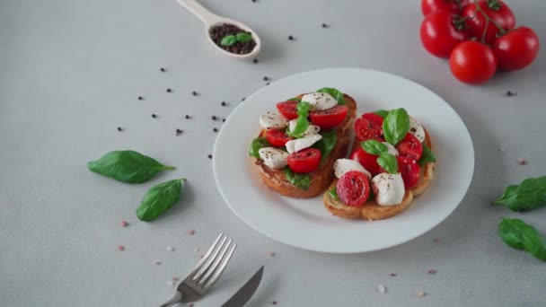 Bruschetta Con Pomodori Mozzarella Foglie Basilico Fondo Chiaro Crostino Caprese — Video Stock
