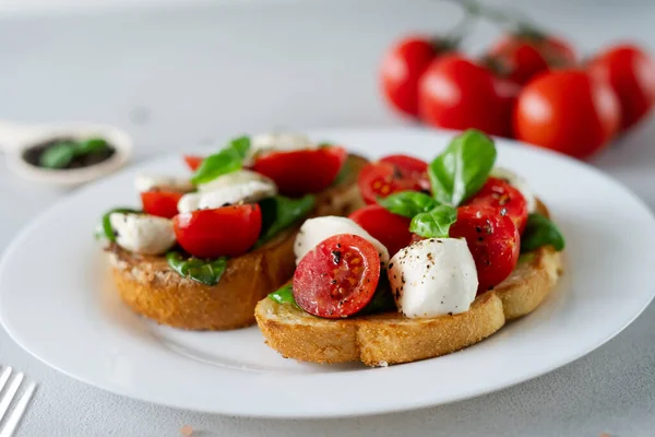 Close Bruschetta Tomatoes Mozzarella Basil Leaves Light Background Crostino Caprese — Stock Photo, Image