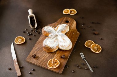 Tahta üzerinde hindistan cevizi cipsi ve vanilya kremalı tatlı spiral çörek. Kahverengi arka planda fırın hamur işleri. Yakın plan.