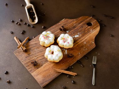 Tahtada beyaz kaplamalı kek ve renkli serpinti.