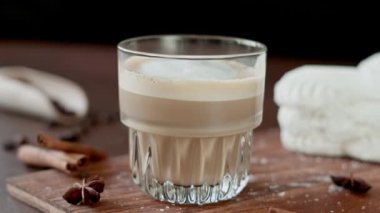 Cappuccino ve tahtada krema olan beyaz kekler. Kahverengi arka planda Latte Macchiato. Yakın plan.