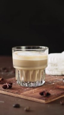 Cappuccino ve tahtada krema olan beyaz kekler. Kahverengi arka planda Latte Macchiato