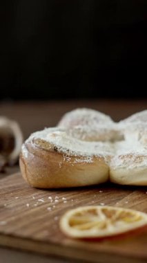 Tahta üzerinde hindistan cevizi cipsi ve vanilya kremalı tatlı spiral çörek. Kahverengi arka planda fırın hamur işleri