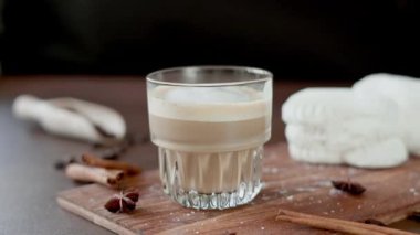 Cappuccino ve tahtada krema olan beyaz kekler. Kahverengi arka planda Latte Macchiato