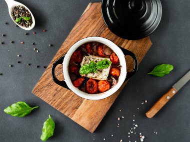 Feta peyniri, mavi soğan, kiraz domatesleri ve siyah arka planda baharatlarla zeytin yağında pişirilmiş fesleğen. Üst görünüm