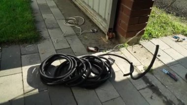 Elektrikçi, kabloyu koruyucu kıvrımlara yerleştirir. Elektrik kabloları için koruyucu kıvrım
