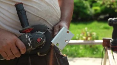 Metal tüpü Angle Grinder kullanarak kesen bir işçi. Parlak kıvılcımlar ve parıltılar