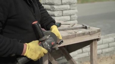Metal tüpü Angle Grinder kullanarak kesen bir işçi. Parlak kıvılcımlar ve parıltılar